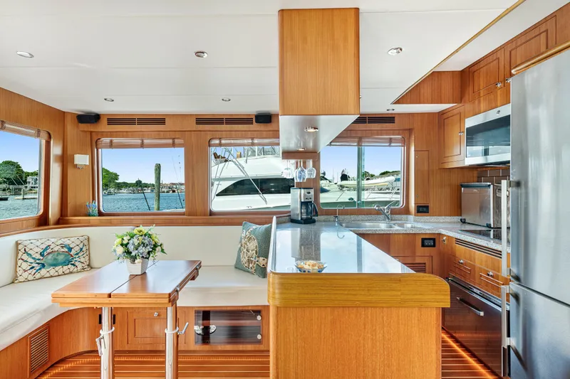 Slide: The Image of Luxurious interior of 2017 North Pacific 49 Pilothouse yacht with modern kitchen and seating area. - 12