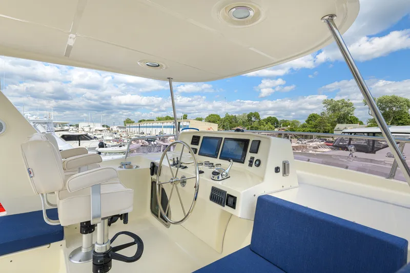 Slide: The Image of Pilothouse of 2017 North Pacific 49 yacht with steering wheel and navigation screens. - 58