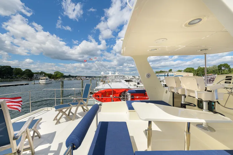 Slide: The Image of Luxurious 2017 North Pacific 49 Pilothouse yacht deck with seating, overlooking marina. - 62