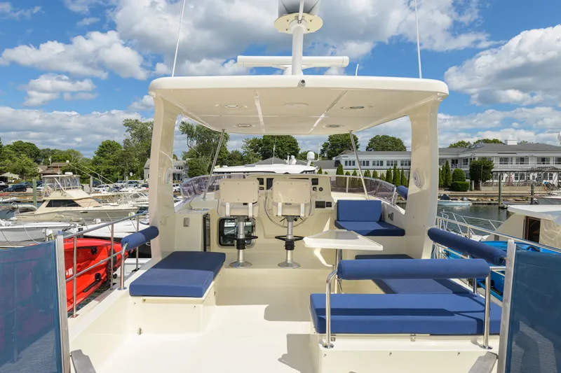 Slide: The Image of 2017 North Pacific 49 Pilothouse yacht with spacious deck and seating, docked at marina. - 64
