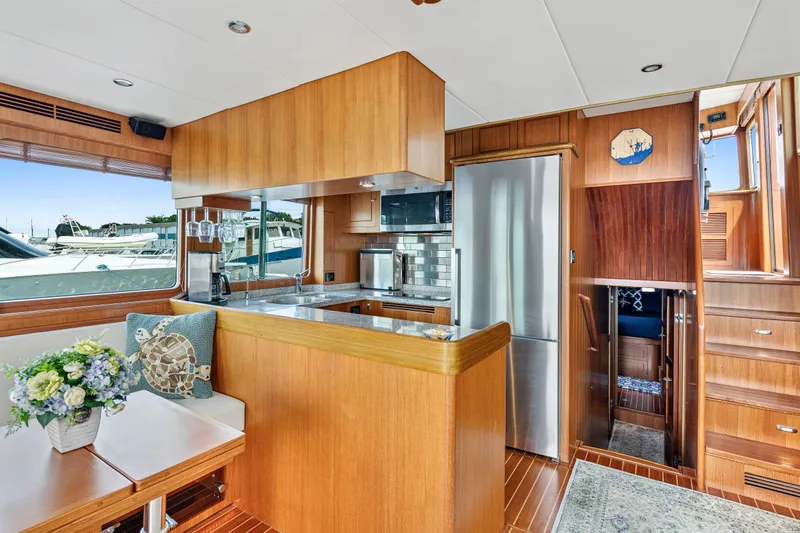 Slide: The Image of Luxurious interior of 2017 North Pacific 49 Pilothouse yacht with modern kitchen and seating area. - 10