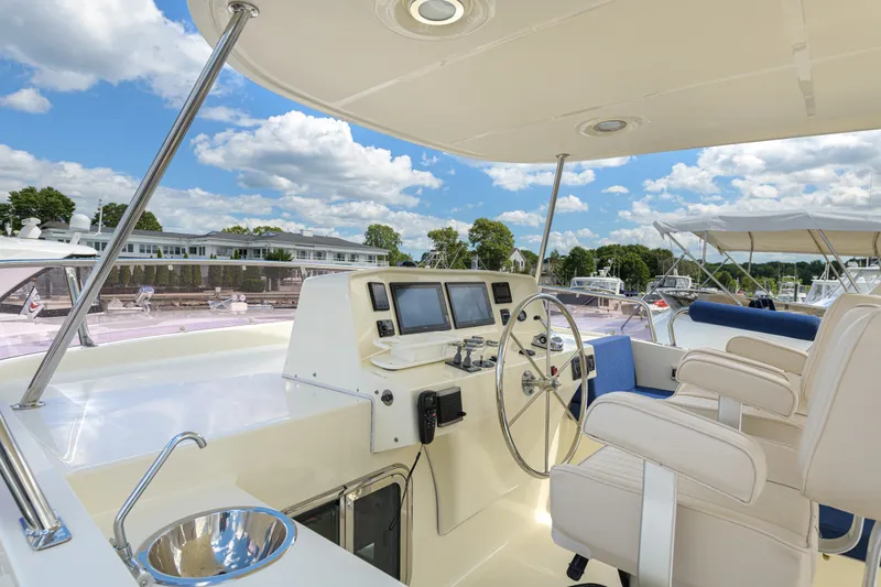 Slide: The Image of 2017 North Pacific 49 Pilothouse yacht helm with dual seats and navigation equipment. - 59