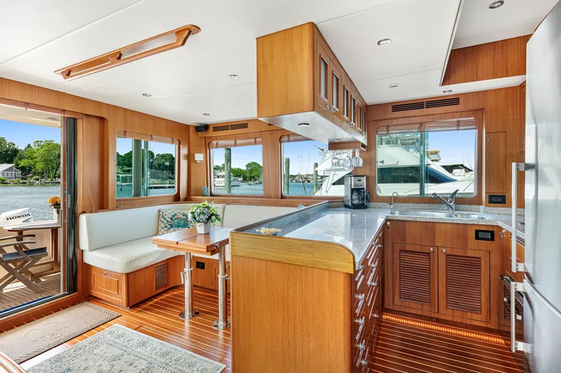 Slide: The Image of Luxurious interior of 2017 North Pacific 49 Pilothouse yacht with modern kitchen and dining area. - 6