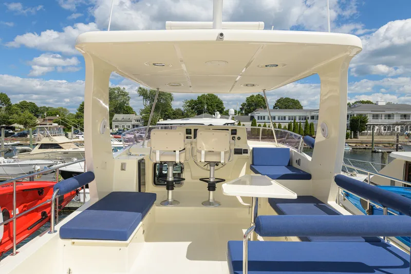 Slide: The Image of Luxurious 2017 North Pacific 49 Pilothouse yacht interior with seating and helm, docked at marina. - 65