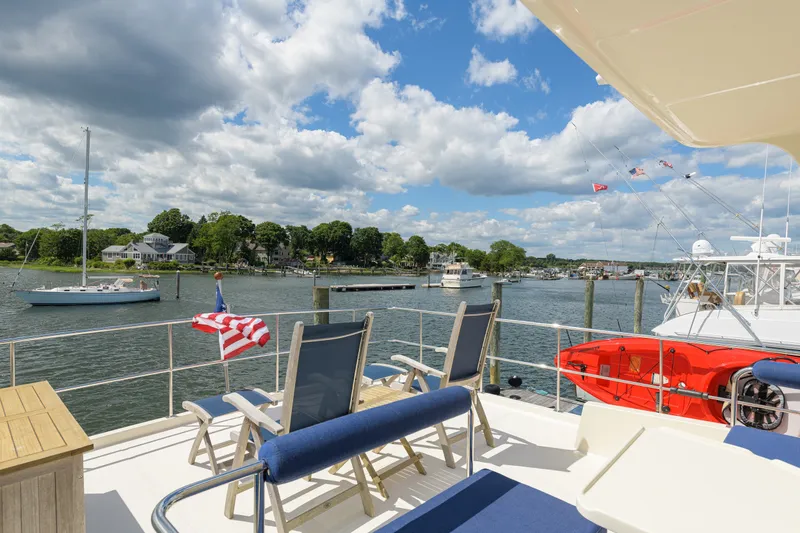 Slide: The Image of Deck view from 2017 North Pacific 49 Pilothouse yacht, overlooking a scenic harbor. - 70
