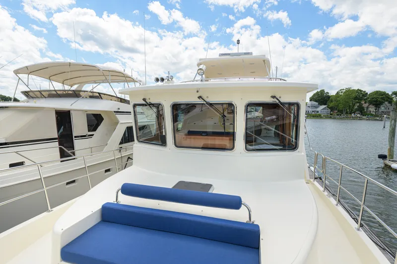 Slide: The Image of 2017 North Pacific 49 Pilothouse yacht docked, featuring spacious deck and pilothouse windows. - 73