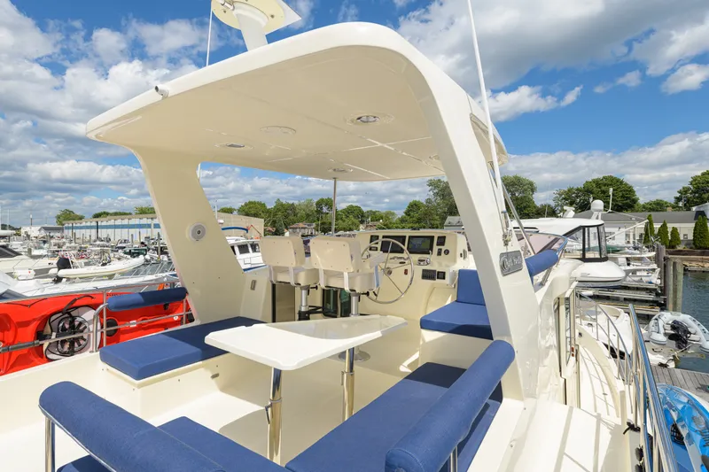 Slide: The Image of 2017 North Pacific 49 Pilothouse yacht with spacious deck and seating at marina. - 60