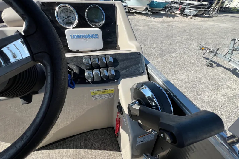 Slide: The Image of 2023 Harris Cruiser 230 boat dashboard with steering wheel and control panel. - 9