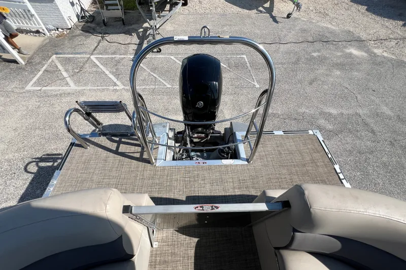 Slide: The Image of 2023 Harris Cruiser 230 boat deck with motor and seating area. - 13