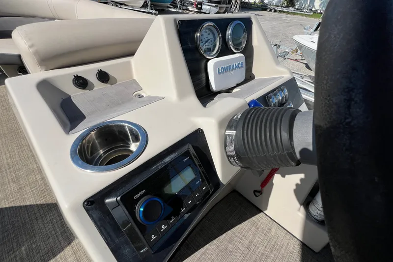 Slide: The Image of 2023 Harris Cruiser 230 dashboard with gauges, cup holder, and navigation system. - 8