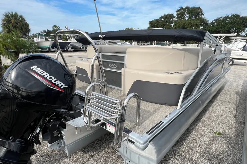 Slide: The Image of 2023 Harris Cruiser 230 pontoon boat with Mercury engine, docked outdoors. - 5