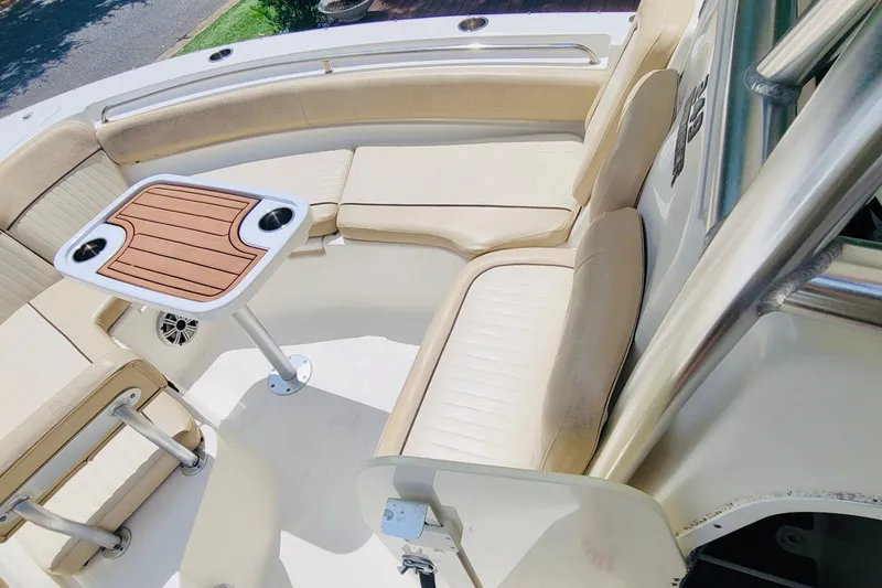 Slide: The Image of 2017 Sea Fox 249 Avenger boat interior with cushioned seating and a wooden table. - 8