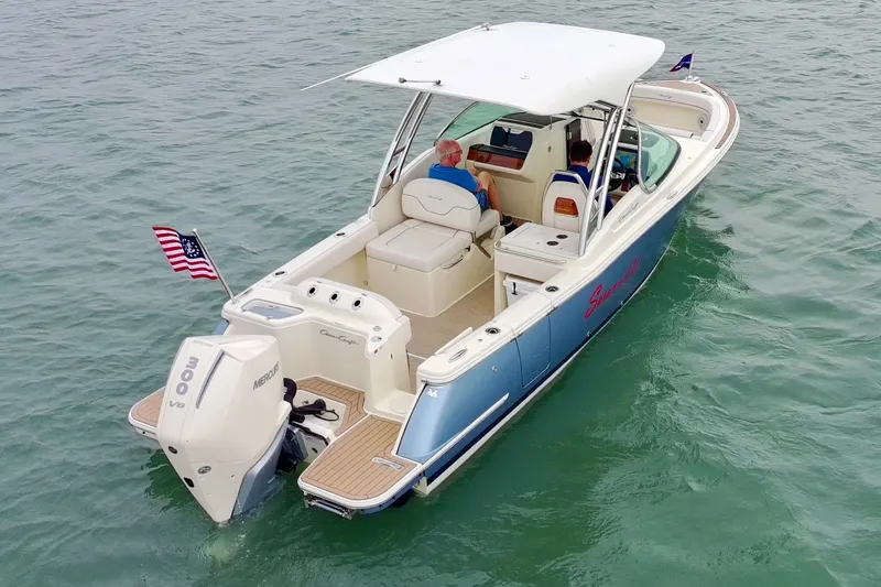 Slide: The Image of 2024 Chris-Craft Calypso 24 boat on water, featuring a Mercury V8 engine and American flag. - 6