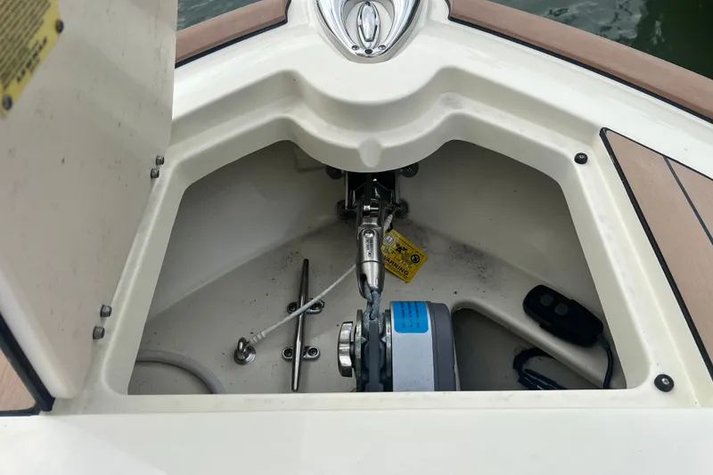 Slide: The Image of Anchor compartment of 2024 Chris-Craft Calypso 24 boat, featuring winch and chain. - 25