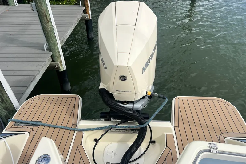 Slide: The Image of 2024 Chris-Craft Calypso 24 with Mercury Verado engine, docked on water. - 27