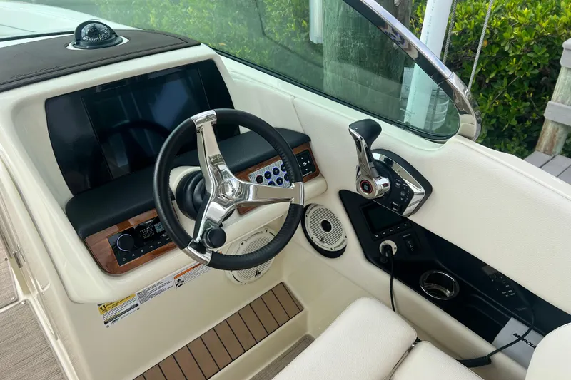 Slide: The Image of 2024 Chris-Craft Calypso 24 helm with steering wheel, controls, and navigation display. - 10