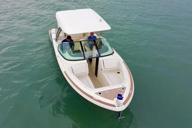 Slide: The Image of 2024 Chris-Craft Calypso 24 boat cruising on calm water with two passengers. - 8
