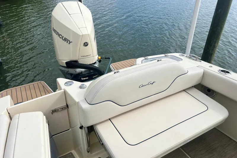 Slide: The Image of 2024 Chris-Craft Calypso 24 boat with Mercury Verado engine, docked on water. - 12
