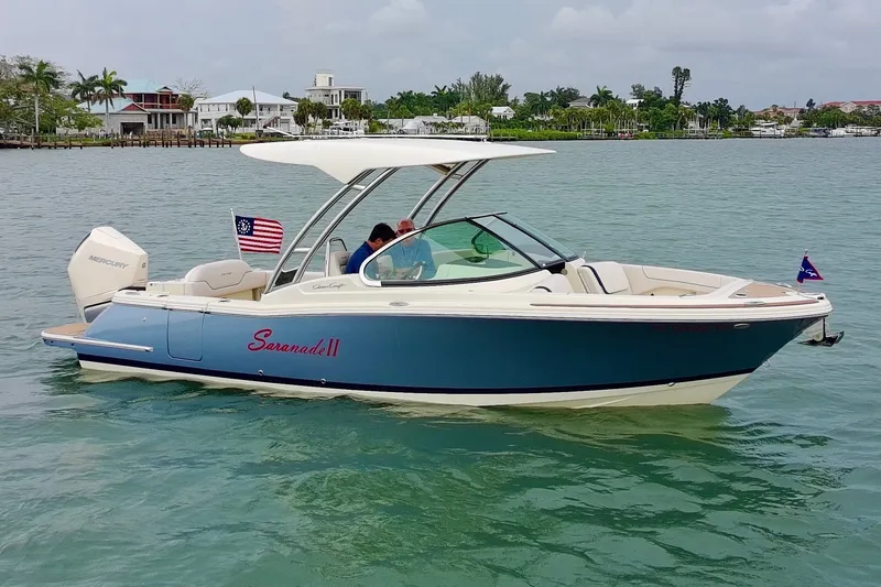 The Image of 2024 Chris-Craft Calypso 24 boat on water, featuring sleek design and American flag. - 0