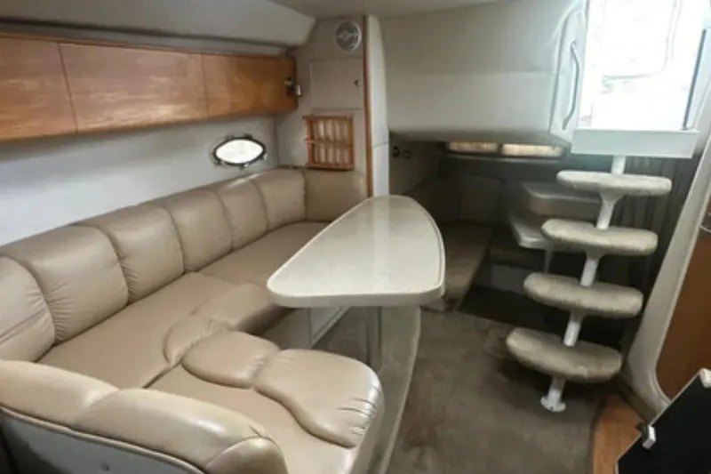 Slide: The Image of Interior of 2004 Larson Cabrio 330 boat with beige seating and compact dining area. - 6