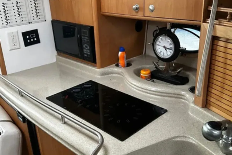 Slide: The Image of 2004 Larson Cabrio 330 boat kitchen with stove, microwave, and clock on countertop. - 5