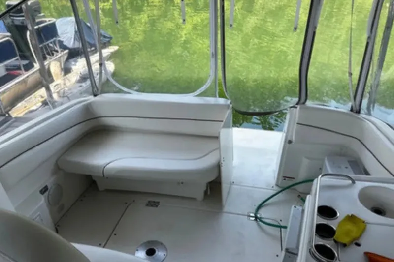 Slide: The Image of Interior of a 2004 Larson Cabrio 330 boat with white seating and windows. - 3