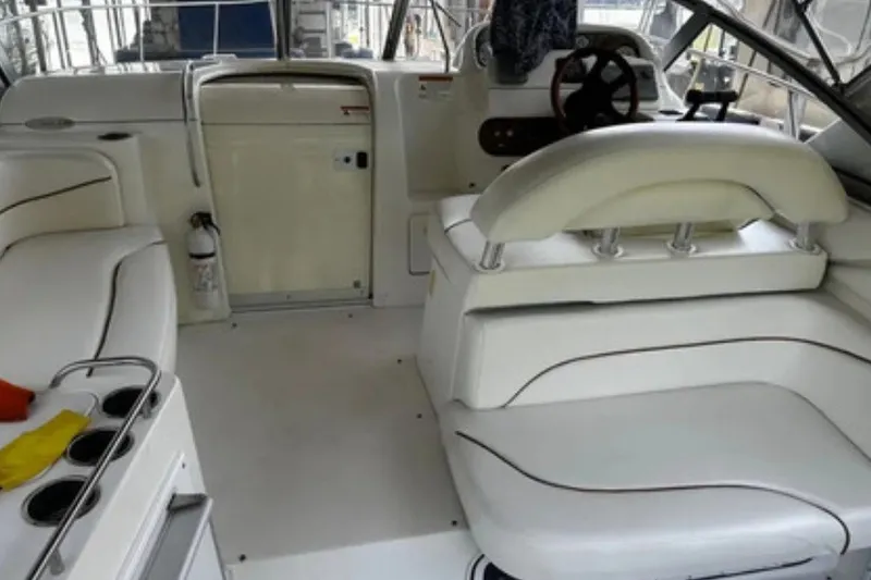 Slide: The Image of Interior of a 2004 Larson Cabrio 330 boat with white seating and steering area. - 4