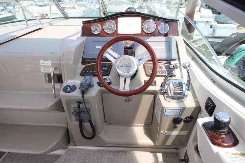 Slide: The Image of 2012 Sea Ray 330 Sundancer boat helm with steering wheel and control panel. - 15
