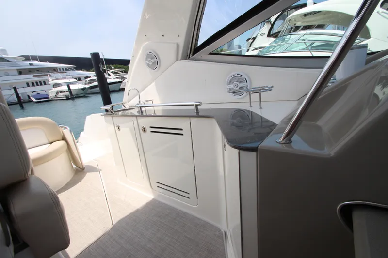 Slide: The Image of 2012 Sea Ray 330 Sundancer yacht interior with kitchenette and marina view. - 14