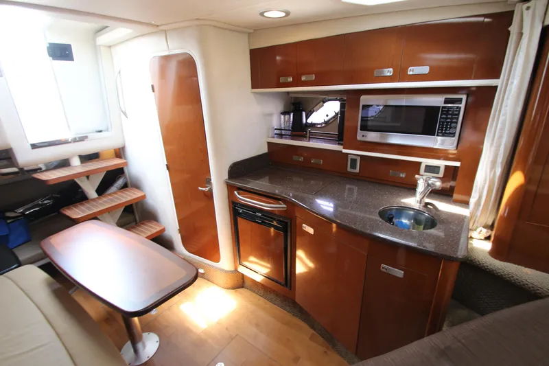 Slide: The Image of Interior of 2012 Sea Ray 330 Sundancer yacht with kitchen and dining area. - 33
