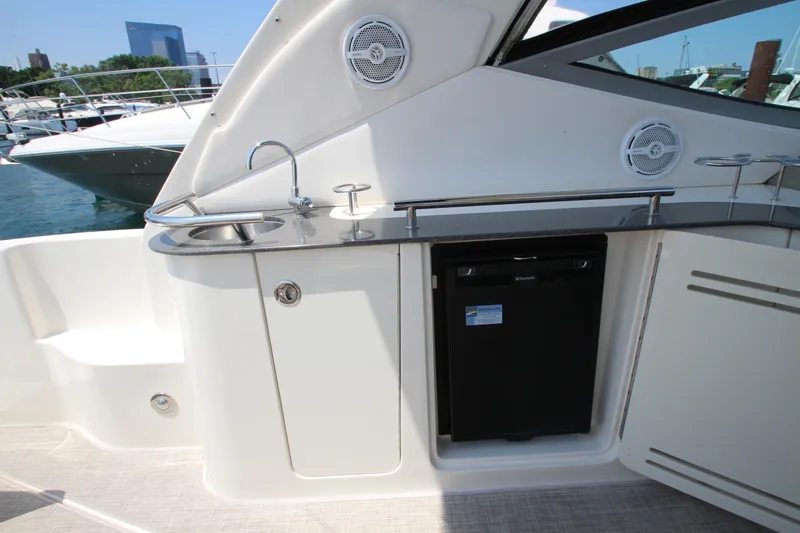 Slide: The Image of 2012 Sea Ray 330 Sundancer boat kitchenette with sink and mini-fridge. - 24