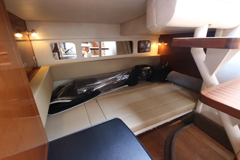 Slide: The Image of Interior cabin of 2012 Sea Ray 330 Sundancer with beige seating and wooden accents. - 38