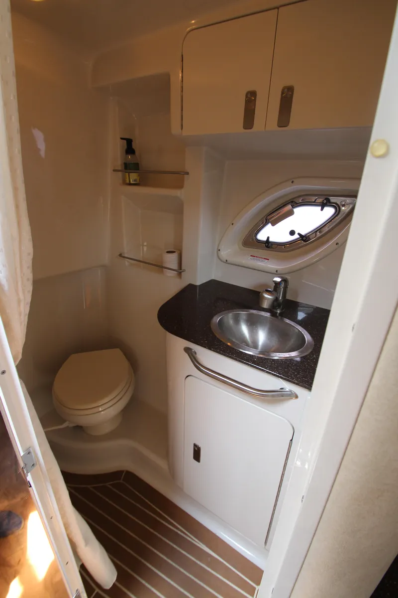 Slide: The Image of 2012 Sea Ray 330 Sundancer bathroom with sink, toilet, and porthole window. - 43
