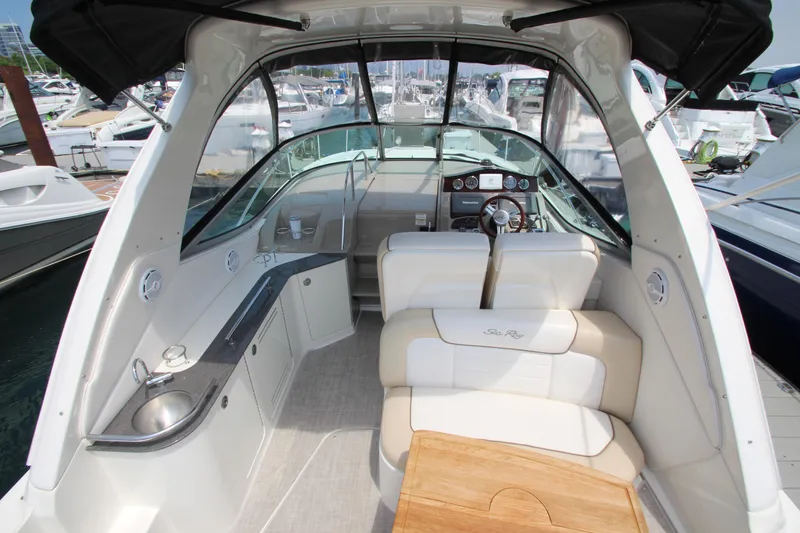 Slide: The Image of 2012 Sea Ray 330 Sundancer boat interior with helm, seating, and kitchenette. - 5