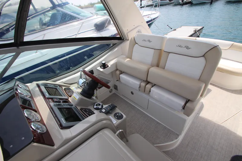 Slide: The Image of Cockpit of 2012 Sea Ray 330 Sundancer with dual helm seats and modern controls. - 18