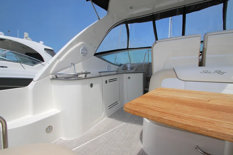 Slide: The Image of Interior of 2012 Sea Ray 330 Sundancer yacht with kitchenette and seating area. - 10