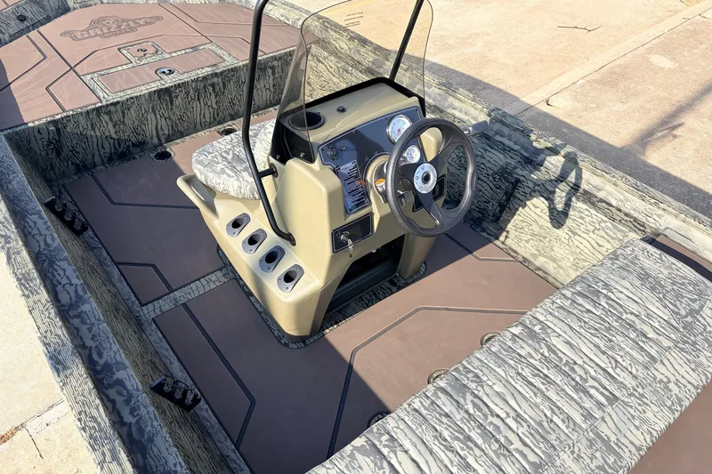 Slide: The Image of 2027 Tracker Grizzly 1860 CC boat interior with steering console and camouflage seating. - 22