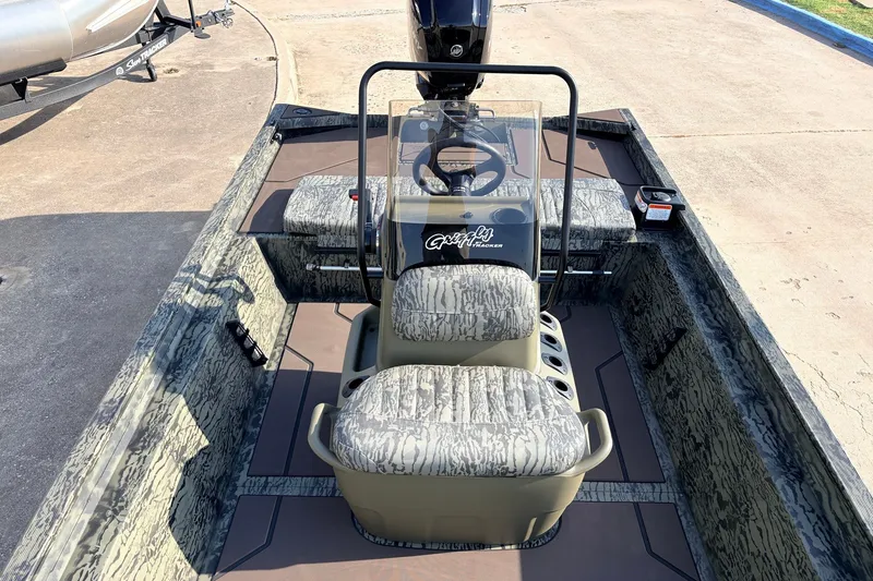 Slide: The Image of 2027 Tracker Grizzly 1860 CC boat interior with camouflage seating and steering console. - 17