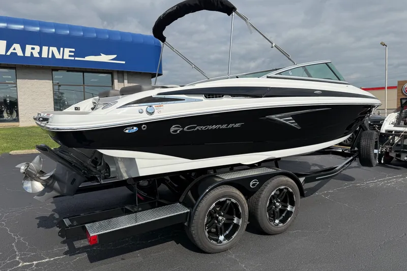 Slide: The Image of 2025 Crownline 220 SS boat on trailer, displayed outside a marine dealership. - 14