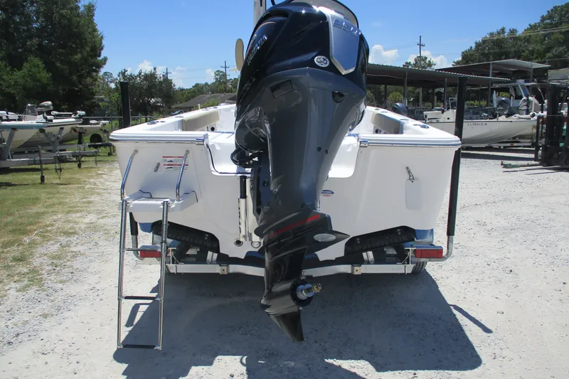 Slide: The Image of 2027 Sportsman Masters 227 Bay Boat with outboard motor and ladder, parked outdoors. - 6