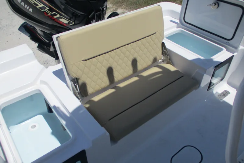 Slide: The Image of 2027 Sportsman Masters 227 Bay Boat interior with beige seating and storage compartments. - 7