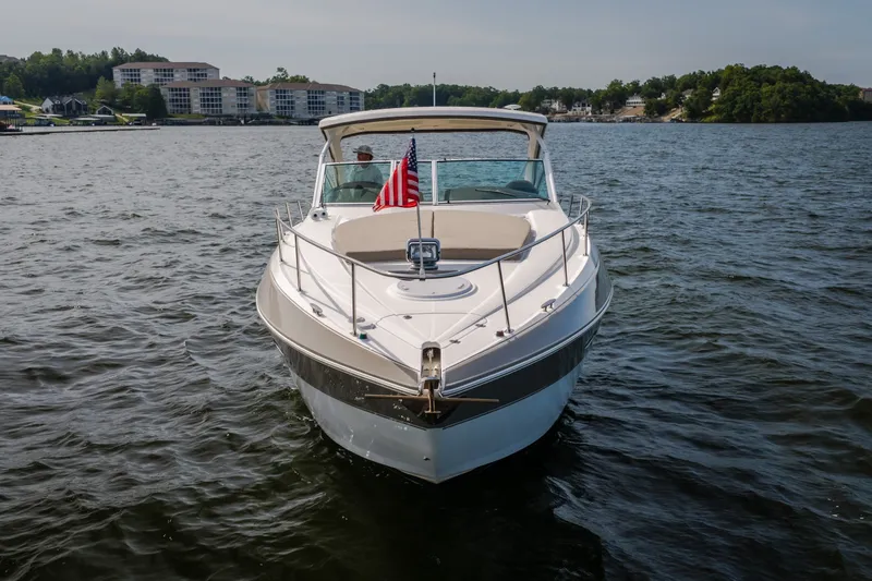 Slide: The Image of 2012 Cruisers Yachts 380 Express on a serene lake with American flag. - 2