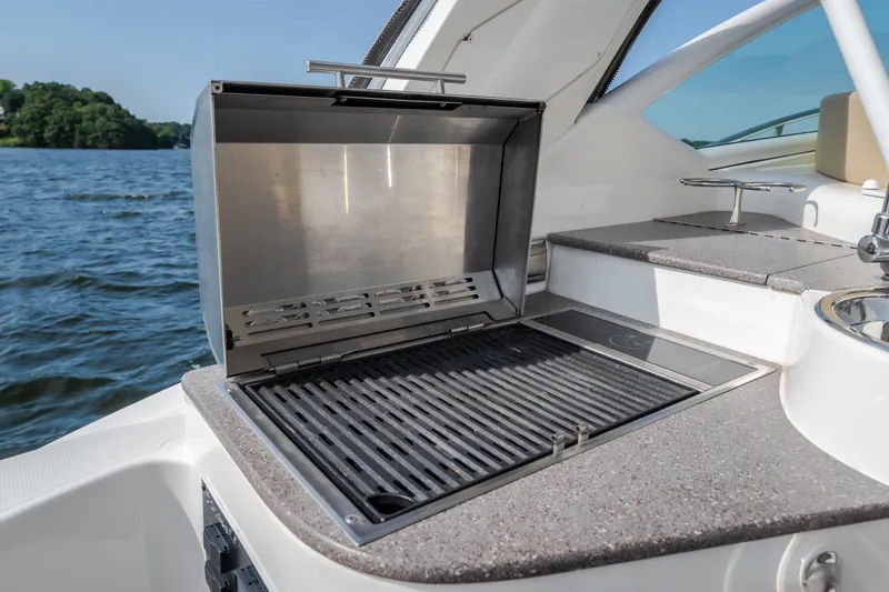 Slide: The Image of Outdoor grill on 2012 Cruisers Yachts 380 Express, overlooking serene water and lush greenery. - 32