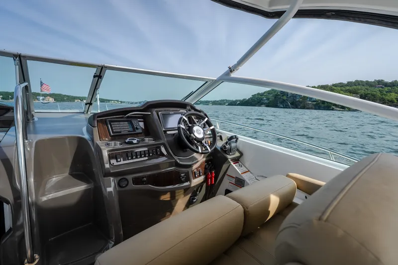 Slide: The Image of 2012 Cruisers Yachts 380 Express helm with scenic lake view and American flag. - 33