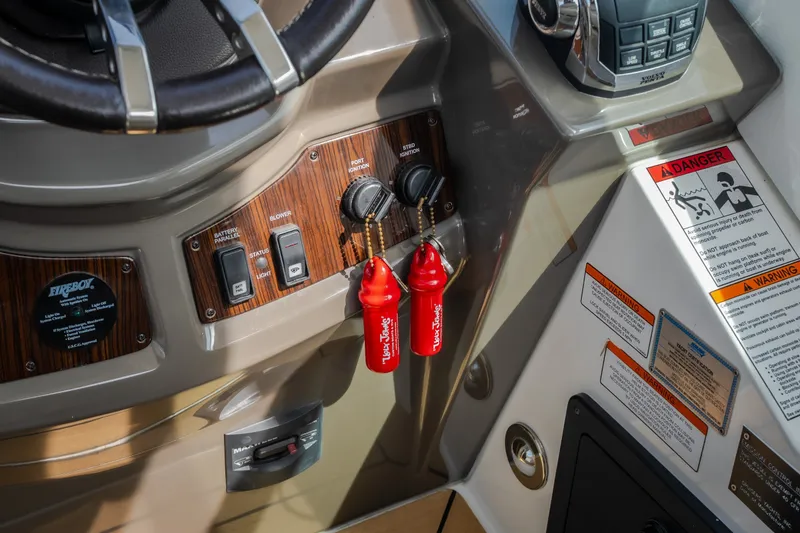 Slide: The Image of Control panel of 2012 Cruisers Yachts 380 Express with ignition keys and safety warnings. - 37