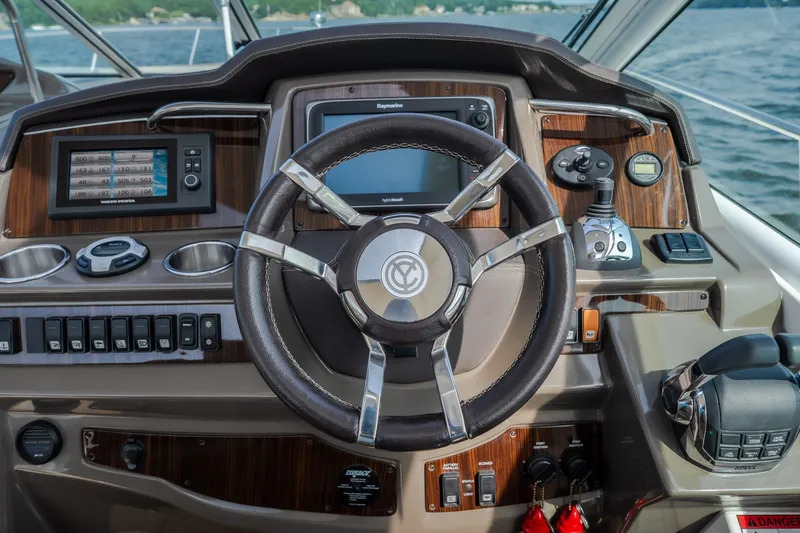 Slide: The Image of Steering wheel and dashboard of 2012 Cruisers Yachts 380 Express, featuring navigation controls. - 26
