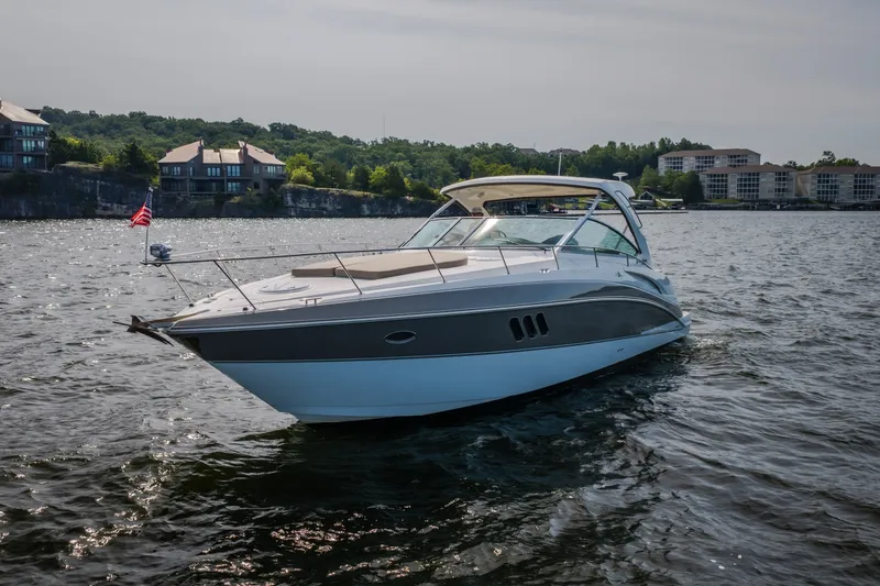 Slide: The Image of 2012 Cruisers Yachts 380 Express on a scenic lake with waterfront homes. - 3