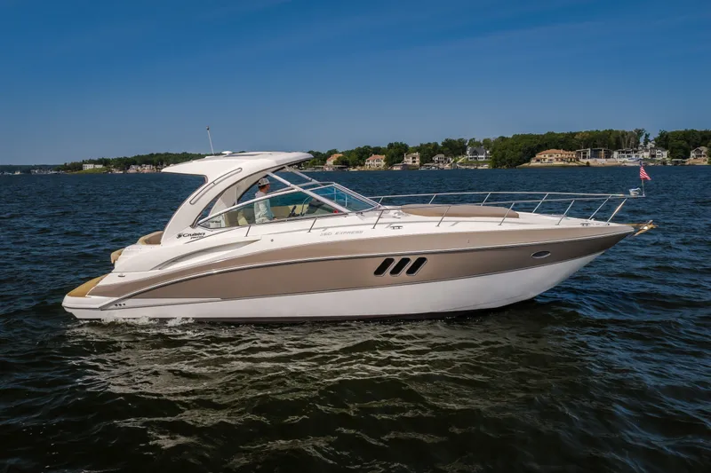 The Image of 2012 Cruisers Yachts 380 Express on a serene lake with waterfront homes in the background. - 0