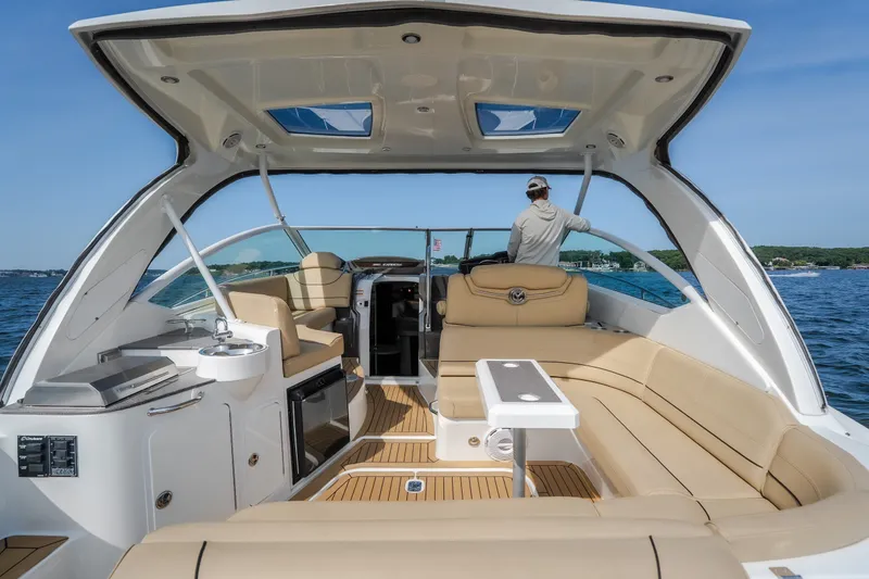 Slide: The Image of 2012 Cruisers Yachts 380 Express interior with seating, table, and helm on open water. - 15