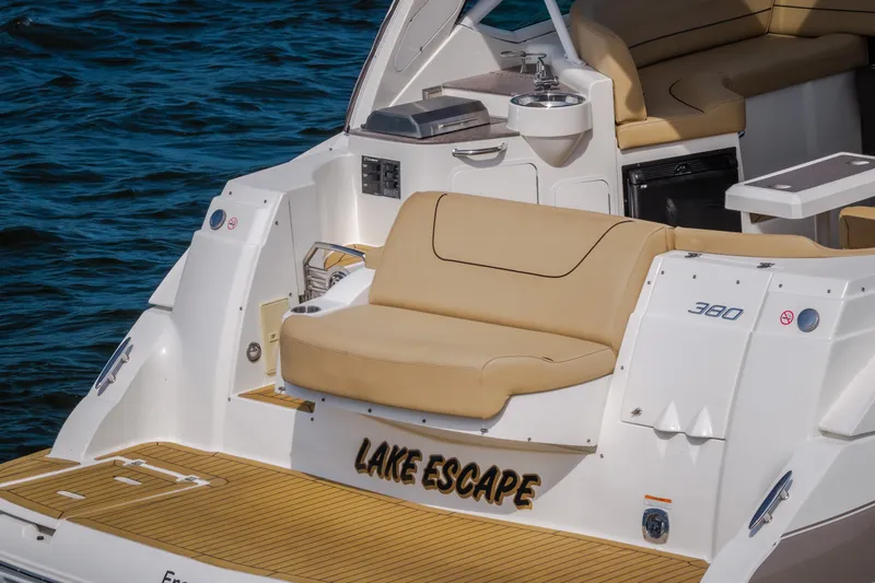 Slide: The Image of 2012 Cruisers Yachts 380 Express boat with tan seating, named "Lake Escape," on water. - 9